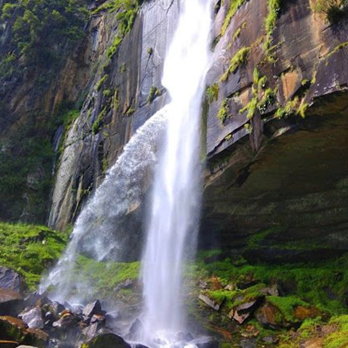Jogini Falls: Serene Waterfall Trek Near Manali Scenic trek to Jogini Falls near Manali, showcasing cascading waters amidst lush green Himalayan landscapes